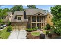 Beautiful brick home featuring a two-car garage, upper and lower porches, and mature landscaping at 265 Lily Cove Dr, Loganville, GA 30052