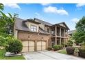 Lovely brick home with an attached two-car garage, a columned porch, and a well-maintained lawn at 265 Lily Cove Dr, Loganville, GA 30052