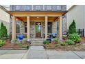 Charming covered front porch features wood columns, manicured landscaping, and a welcoming entrance at 6425 Bellmoore Park Ln, Johns Creek, GA 30097