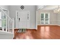Bright foyer featuring hardwood floors, a staircase with white railings, and elegant lighting fixtures at 1960 Barnes Mill Rd, Marietta, GA 30062
