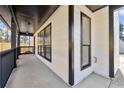 Covered porch features black railings, a concrete floor, an orange door, and black trimmed windows at 459 Orchard Dr, Stone Mountain, GA 30083