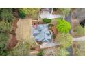 Aerial view of a private backyard featuring a stone patio, lush lawn, and mature trees at 107 Grand Ave, Suwanee, GA 30024