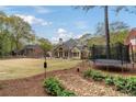 Spacious backyard with lush lawn, mature trees, and a comfortable patio perfect for outdoor entertaining at 107 Grand Ave, Suwanee, GA 30024