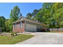 Features a brick and vinyl exterior, an attached garage, and a spacious driveway at 210 Mels Way, Stockbridge, GA 30281