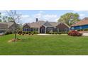 Charming brick home with a well-manicured lawn and colorful landscaping at 7425 Twin Creek Ct, Cumming, GA 30041