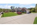 Beautiful home with a wide driveway, manicured lawn, and charming brick and siding exterior at 7425 Twin Creek Ct, Cumming, GA 30041