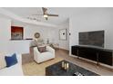 A living room with a ceiling fan, modern furnishings, and an open layout, connecting to a dining area and kitchen at 1075 Peachtree Ne Walk # A421, Atlanta, GA 30309