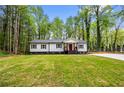 Charming single-story home featuring a well-manicured lawn and beautiful trees surrounding the property at 2798 Hutchins Rd, Lawrenceville, GA 30044