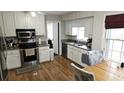Bright kitchen features stainless steel appliances, white cabinets, and hardwood floors at 2912 Pathview Ln, Marietta, GA 30062