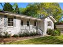 View of the inviting exterior with its classic white brick, gray shutters, and covered porch entrance to home at 5132 Foxwood Ct, Atlanta, GA 30360