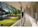 Covered front porch featuring views of the lawn and surrounding landscape with crisp white columns and railings at 5132 Foxwood Ct, Atlanta, GA 30360