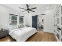 Serene bedroom with hardwood floors, neutral tones, modern fan, and a barn door leading to the bathroom at 878 Dill Sw Ave, Atlanta, GA 30310