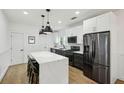 Modern kitchen featuring stainless steel appliances, white cabinets, a marble countertop island, and hardwood floors at 878 Dill Sw Ave, Atlanta, GA 30310
