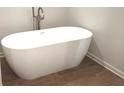 Freestanding modern bathtub with elegant fixtures and warm wood-look tile flooring in a relaxing bathroom at 1594 Sungrown Way, Mcdonough, GA 30253