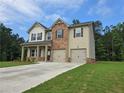 Two-story home featuring a brick and vinyl exterior, a two-car garage, and a well-manicured front lawn at 1594 Sungrown Way, Mcdonough, GA 30253