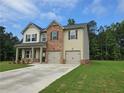 Two-story home featuring a brick and vinyl exterior, a two-car garage, and a well-manicured front lawn at 1594 Sungrown Way, Mcdonough, GA 30253
