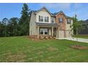 Two-story home featuring a brick and vinyl exterior, a two-car garage, and a well-manicured front lawn at 1594 Sungrown Way, Mcdonough, GA 30253