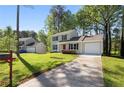 Two-story home featuring a front yard, a driveway and an attached garage in a lush setting at 2965 Carrie Farm Nw Rd, Kennesaw, GA 30144