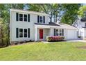 Charming two-story home with a well-maintained lawn, a red front door and lush landscaping at 2965 Carrie Farm Nw Rd, Kennesaw, GA 30144