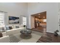 Sunlit living room with hardwood floors, a white couch, and an open layout connected to the adjacent kitchen at 108 Wheelers Dr, Dallas, GA 30157