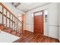 Foyer with hardwood floors leads past the staircase to a rustic stained front door, offering style and character at 1366 Maple Ridge Dr, Suwanee, GA 30024