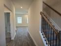 Hallway view leading to living area and staircase with carpet and rod iron railing at 1636 Fuma Leaf Way, Mcdonough, GA 30253