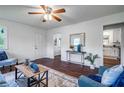 Cozy living room featuring hardwood floors, a ceiling fan, and plenty of natural light from the windows at 80 E Howard St, Kingston, GA 30145