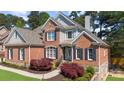 Charming brick home featuring manicured landscaping, a stone chimney and a welcoming entrance at 6252 Fernstone Trl, Acworth, GA 30101