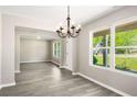 Dining room featuring hardwood floors, modern lighting, and lots of windows with a view to the front yard at 960 Revere Way, Hampton, GA 30228