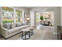 Bright living room featuring large windows, neutral tones, and an open layout to the dining area at 960 Revere Way, Hampton, GA 30228
