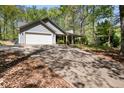 Exterior shot of home featuring a long driveway, front lawn, and attached two-car garage at 11268 Flat Shoals Rd, Covington, GA 30016