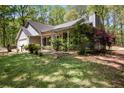 Charming single-story home featuring a front lawn, mature trees, and covered porch at 11268 Flat Shoals Rd, Covington, GA 30016