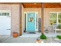 Charming front porch with brickwork, a welcoming turquoise door, and a 'WELCOME' sign at 2365 Oakland Trail Way, Lawrenceville, GA 30044