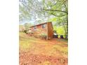 A view of the backyard of the house with grass and foliage and some trees at 1445 Diplomat Dr, Riverdale, GA 30296