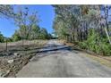 Long asphalt driveway leading up to a home surrounded by trees and foliage in the background at 3211 Thompson Mill Rd, Buford, GA 30519