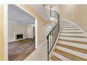Elegant foyer featuring a gracefully curved staircase with a wrought iron railing and an adjacent living area with a fireplace at 5400 Roswell Rd # J2, Atlanta, GA 30342