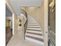 Elegant foyer showcasing a gracefully curved staircase with a wrought iron railing and neutral-toned walls with beautiful tile flooring at 5400 Roswell Rd # J2, Atlanta, GA 30342