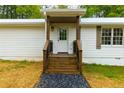 Front entrance featuring wooden steps, a white door, and a landscaped walkway, enhancing curb appeal at 505 Cedar Creek Nw Rd, Cartersville, GA 30121