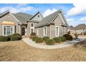 Well-maintained front yard featuring lush greenery, a curved walkway, and a charming brick home exterior at 135 Antoinette Ave, Mcdonough, GA 30252