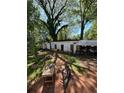 Wide angle showing the backyard with two sheds, a makeshift gym, and overgrown trees at 2245 Panstone Sw Dr, Marietta, GA 30060