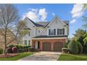Charming two-story home featuring a brick facade, attached two-car garage, landscaped front yard, and a welcoming entrance at 3465 Caney Creek Ln, Cumming, GA 30041