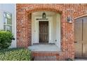 Inviting front entrance featuring a brick archway, dark wood door with sidelights, and classic lantern lighting at 3465 Caney Creek Ln, Cumming, GA 30041