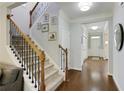 Elegant foyer featuring a staircase with wrought iron spindles and gleaming hardwood floors at 5075 Chase Ln, Cumming, GA 30040