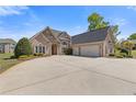 Beautiful brick home featuring an expansive driveway leading to a spacious three-car garage at 755 Peninsula Overlook, Hampton, GA 30228