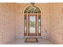 Elegant front door with decorative glass, sidelights, and brick surround at 755 Peninsula Overlook, Hampton, GA 30228