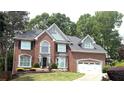 Attractive brick home with attached garage, complemented by an arched window and a landscaped front yard at 1081 Talon Trce, Lawrenceville, GA 30043