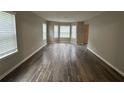 Bright living room featuring hardwood floors, bay windows, and neutral paint, perfect for relaxing at 3472 Riverview Chase Way, Ellenwood, GA 30294