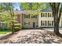 Charming two-story townhouse with tan siding and blue shutters plus mature shade trees in the front yard at 706 Twin Brooks Se Ct, Marietta, GA 30067