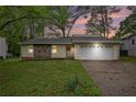 Charming single-story home featuring stone accents and a well-maintained front yard at sunset at 1248 Reilly Ln, Clarkston, GA 30021
