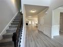 Open foyer with hardwood floors, stairs, and views into the living room and kitchen at 80 Hawthorn Ln, Covington, GA 30014